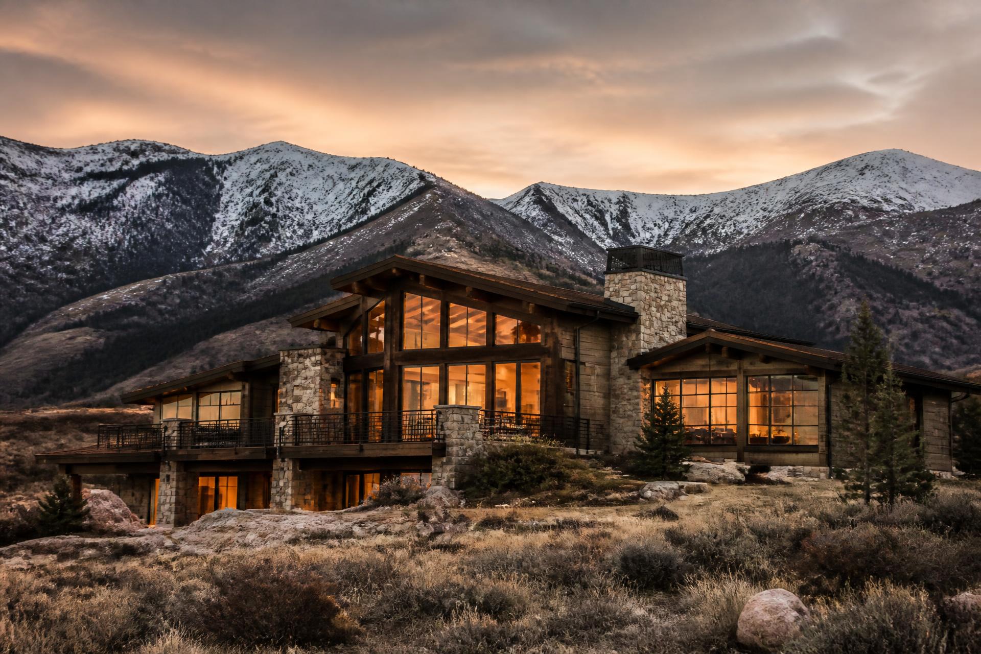 Wasatch Back mountain home at dusk with warm interior light